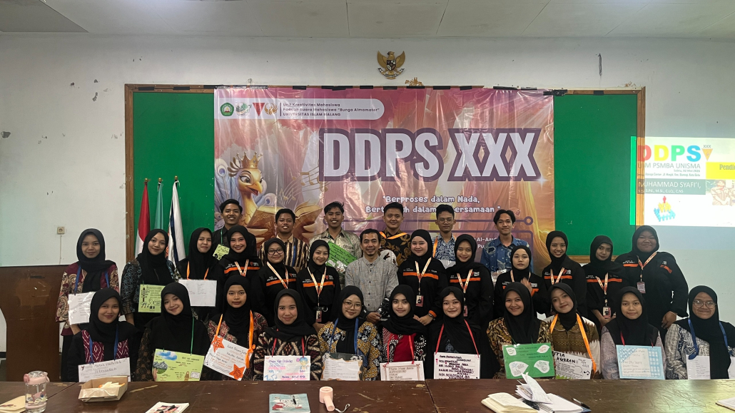 "Foto bersama peserta dan panitia Diklat Dasar Paduan Suara (DDPS XXX) di depan spanduk besar di area outdoor kampus."